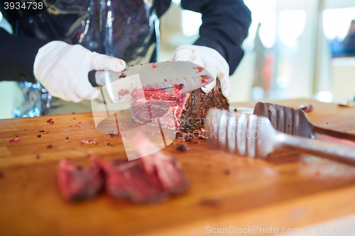 Image of Butcher cutting slices of fresh beef