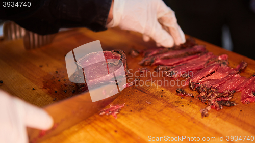 Image of Butcher cutting slices of fresh beef