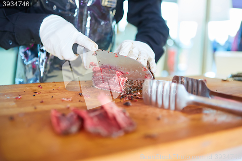 Image of Butcher cutting slices of fresh beef