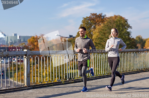 Image of happy couple running outdoors