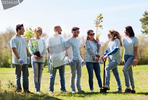 Image of group of volunteers with trees and rake in park