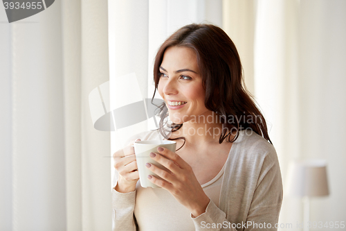 Image of happy woman with cup of tea or coffee at home