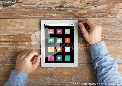 Image of close up of male hands to tablet pc on table