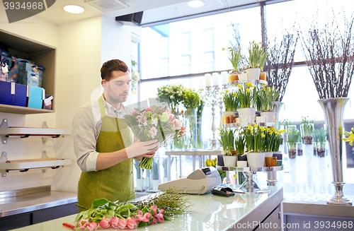 Image of florist man making bunch at flower shop