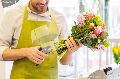 Image of close up of florist man with flowers and pruner