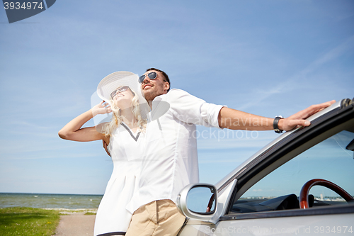 Image of happy couple hugging near cabriolet car at sea