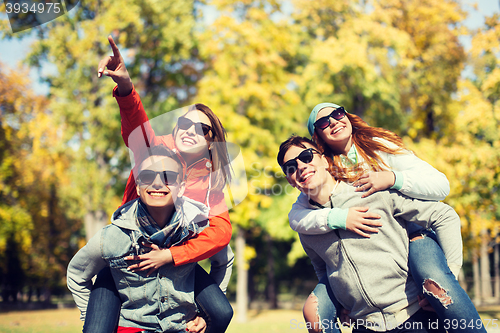 Image of happy friends in shades having fun at autumn park