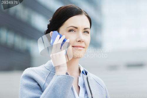 Image of young smiling businesswoman calling on smartphone