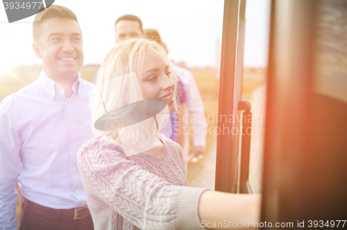 Image of group of happy passengers boarding travel bus