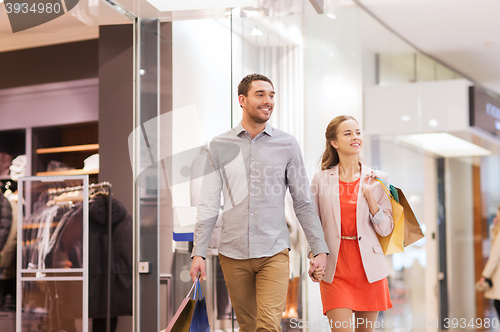 Image of happy young couple with shopping bags in mall