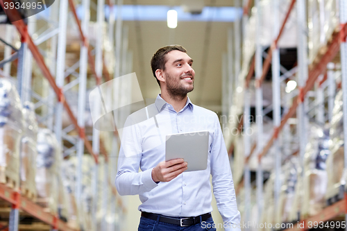 Image of happy businessman with tablet pc at warehouse