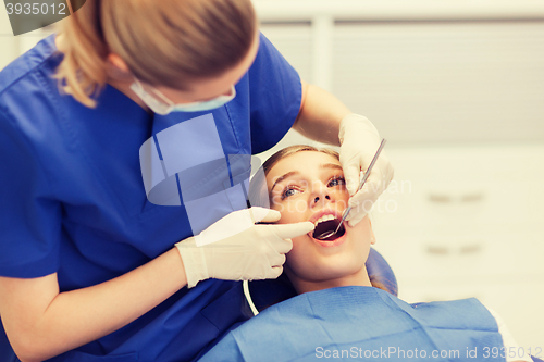 Image of female dentist checking patient girl teeth