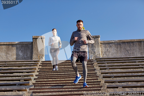 Image of couple running downstairs in city