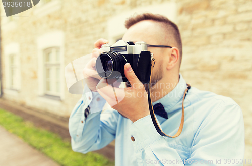 Image of close up of hipster man with film camera in city