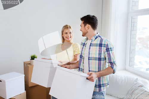 Image of smiling couple with big boxes moving to new home