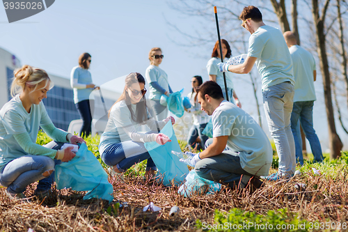 Image of volunteers with garbage bags cleaning park area