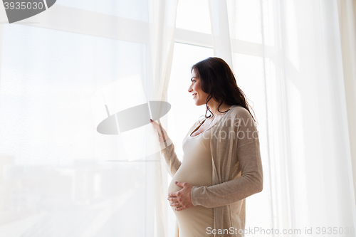 Image of close up of happy pregnant woman looking to window