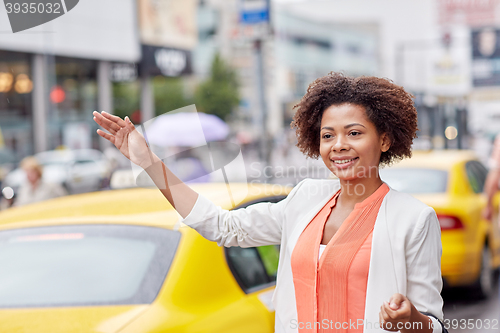 Image of happy african woman catching taxi