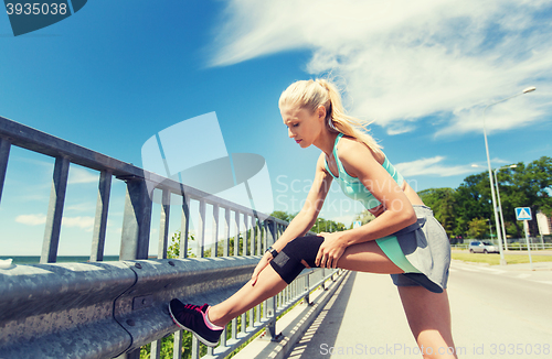 Image of young woman with injured knee or leg outdoors