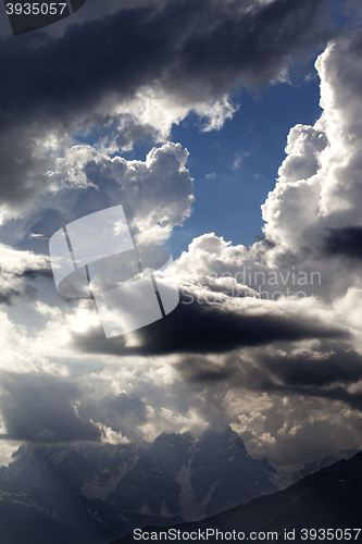 Image of High mountains before rain and sunlight clouds