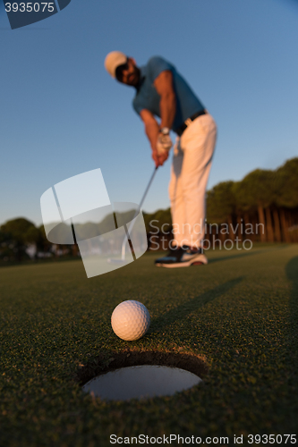 Image of golfer  hitting shot at golf course