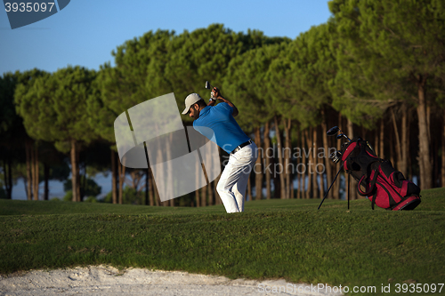 Image of golfer hitting a sand bunker shot on sunset