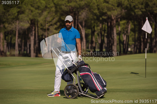 Image of golf player walking with wheel bag