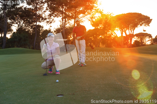 Image of couple on golf course at sunset