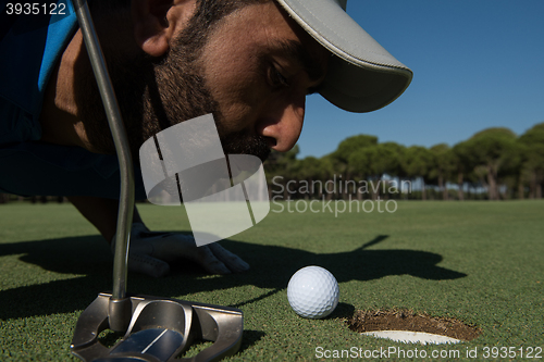 Image of golf player blowing ball in hole