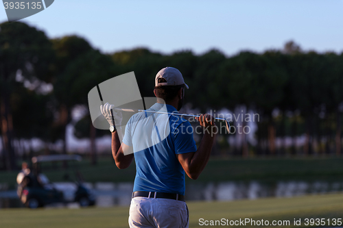 Image of golfer from back at course looking to hole in distance