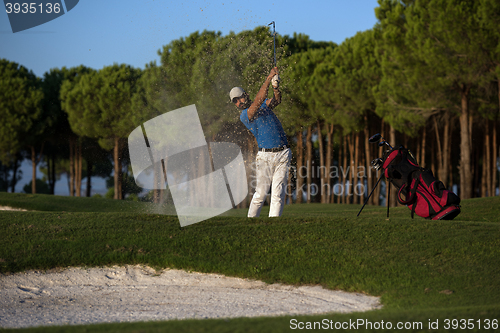 Image of golfer hitting a sand bunker shot on sunset