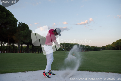 Image of golfer hitting a sand bunker shot on sunset