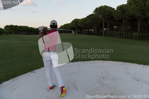 Image of golfer hitting a sand bunker shot on sunset