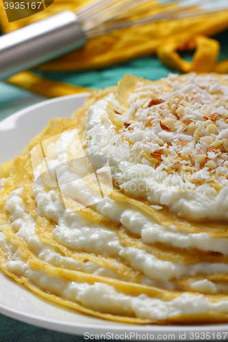 Image of Pile of crepes with cottage cheese and grated coconut