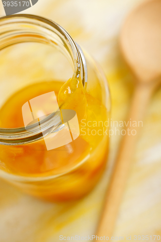 Image of Yellow mirabelle plum jam blob over glass jar screw