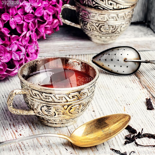 Image of Still life with tea and branch of lilac