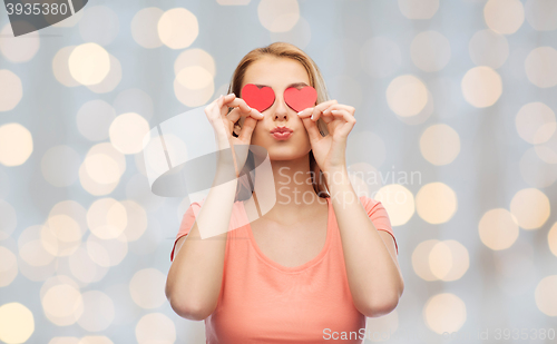 Image of happy young woman with red heart shapes on eyes