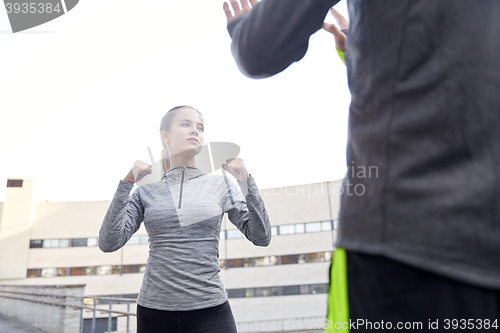 Image of woman with trainer working out self defense strike