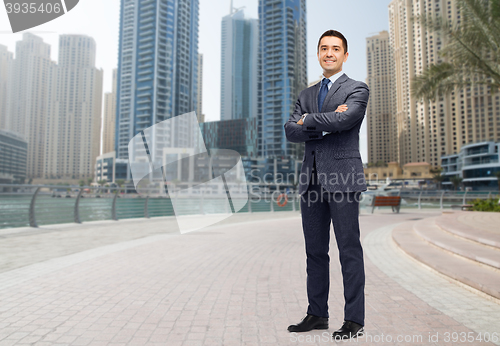 Image of happy smiling businessman in suit over dubai city