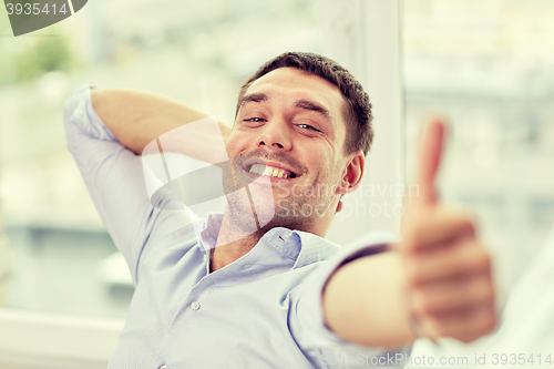 Image of smiling man showing thumbs up at home or office