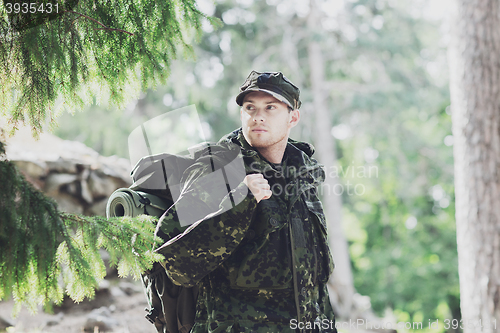 Image of young soldier with backpack in forest