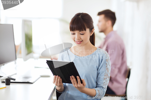 Image of happy creative female office worker with tablet pc