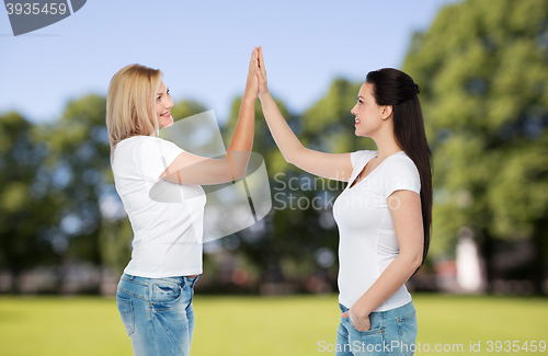 Image of group of happy different women in white t-shirts