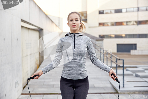 Image of woman exercising with jump-rope outdoors