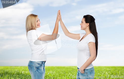 Image of group of happy different women in white t-shirts