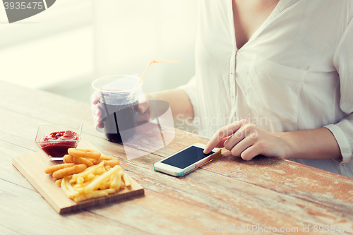 Image of close up of woman with smart phone and fast food