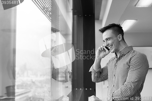 Image of young business man using smart phone at office