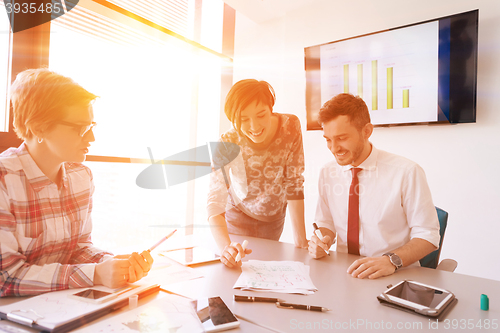 Image of startup business team on meeting at modern office with sunset in