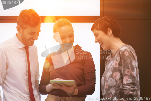 Image of young business people group working on tablet computer with sunr