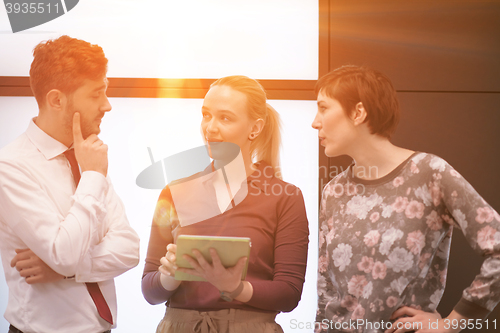 Image of young business people group working on tablet computer with sunr